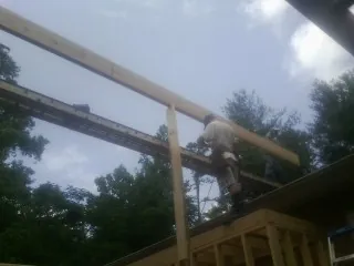 Carpenter setting a ridge beam over a new addition frame — Ice Dam Removal by Roofing Brothers in Coalmont